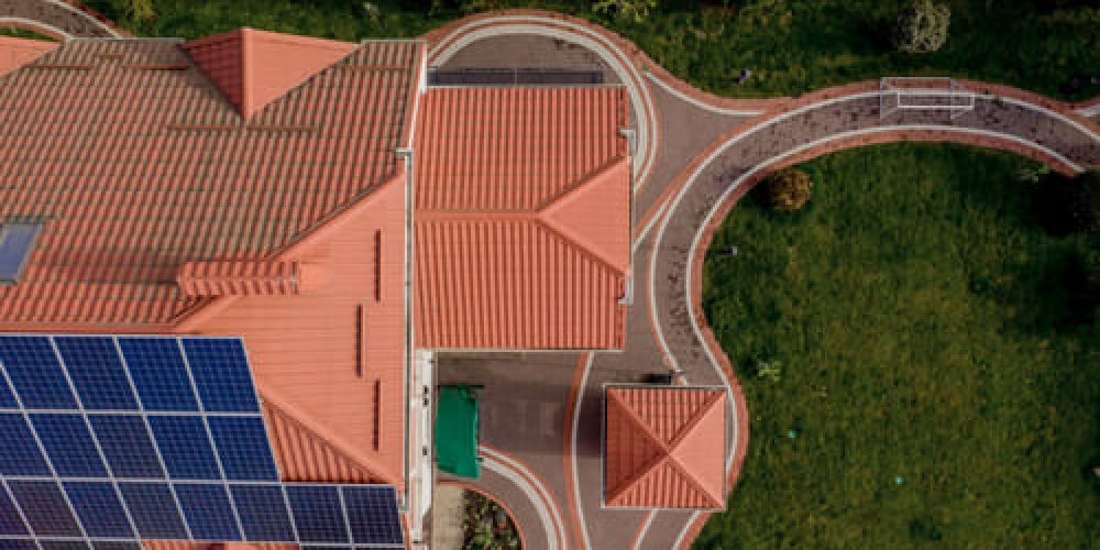 aerial-top-view-new-modern-residential-house-cottage-with-blue-panels-renewable-ecological-green-energy-production-concept