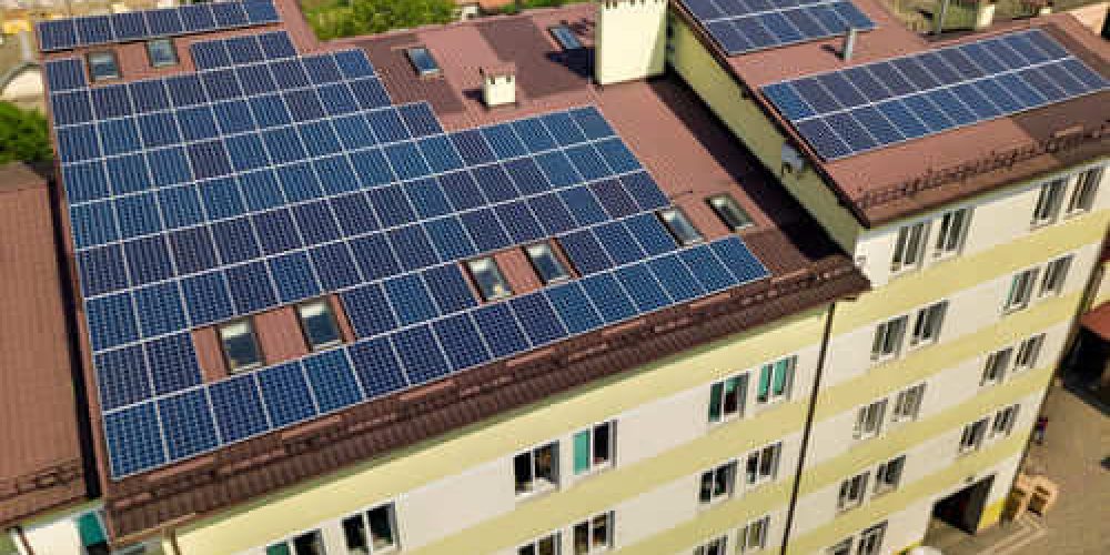 aerial-view-many-solar-panels-mounted-industrial-building-roof (1)